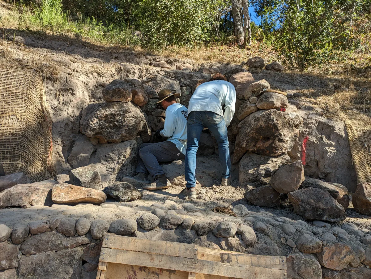 Water & Stone craftspeople setting natural stone into a hillside water feature